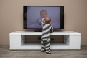 baby touching television that could topple onto him